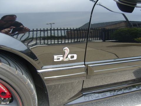 2007 Ford Mustang - Close-up of a black Ford Mustang's side, showing the 5.0 fender badge and rocker panel trim.