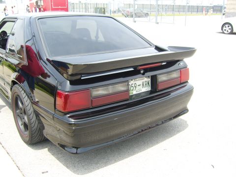 2007 Ford Mustang - Rear view of a black 1987 Ford Mustang, identified by its distinctive body style and spoiler.