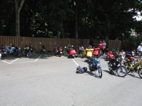 1981 Garelli Rally Sport - A collection of vintage mopeds and scooters are parked in an outdoor lot on a sunny day.