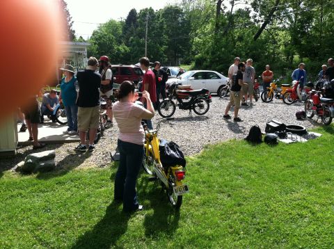 1981 Garelli Rally Sport - A gathering of people around several mopeds on a sunny day.