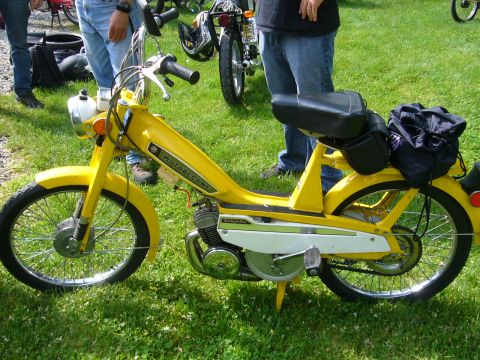 1981 Garelli Rally Sport - A yellow Motobecane moped is parked on grass with other vehicles and people in the background.