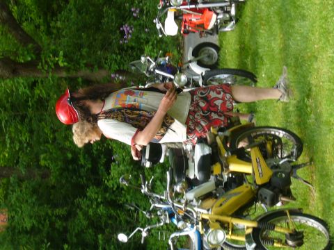 1981 Garelli Rally Sport - Several mopeds are parked on grass with two people nearby. One moped is yellow and in the foreground.