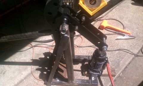 1990 Ford Bronco - Metal fabrication equipment is shown with tools and a hydraulic jack on a concrete surface.