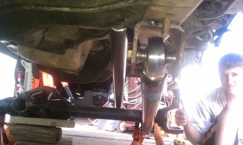 1990 Ford Bronco - Underbody shot of a truck up on jack stands showing a solid front axle housing with a fabricated radius-arm or link mount welded to it, a l…