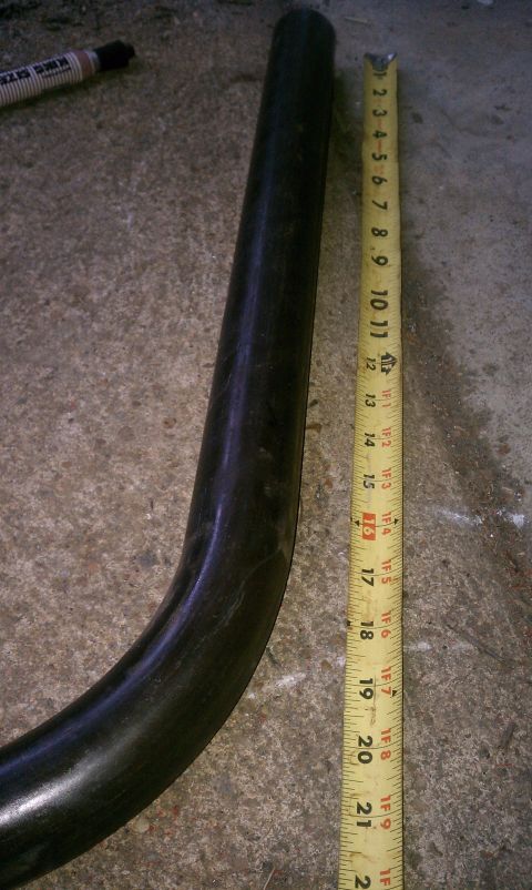 1990 Ford Bronco - A close-up of a bent metal tube with a tape measure indicating its length.