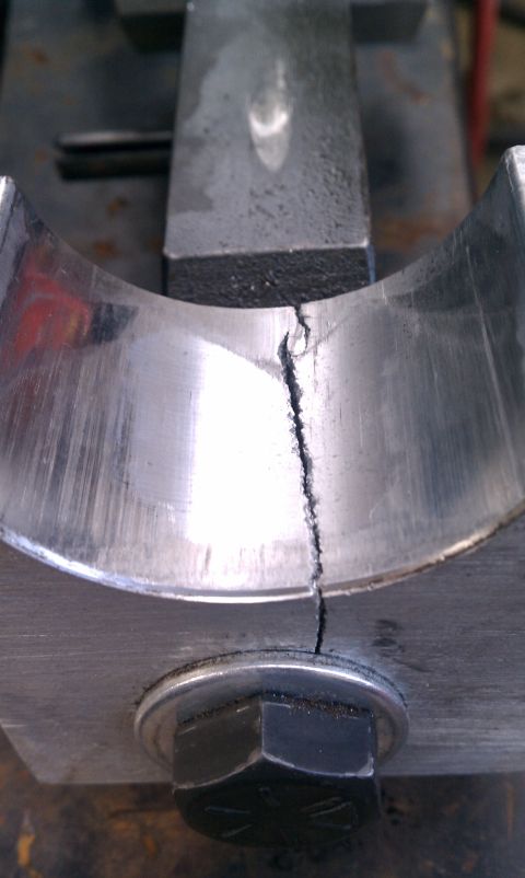 1990 Ford Bronco - A severely cracked engine bearing is shown, indicating significant mechanical failure.