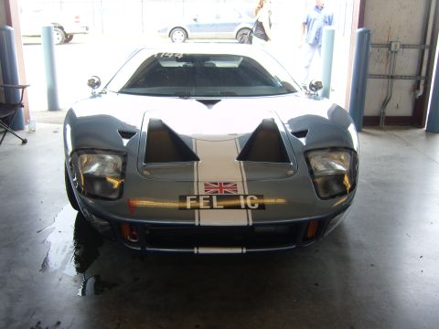 2007 Ford Mustang - A classic Ford GT40 is parked in a garage, displaying its iconic front end with racing stripes.