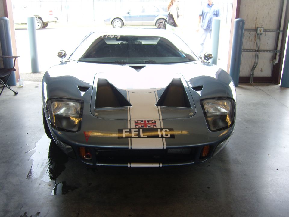Gray Ford GT40 with white racing stripes and a Union Jack plate, parked indoors