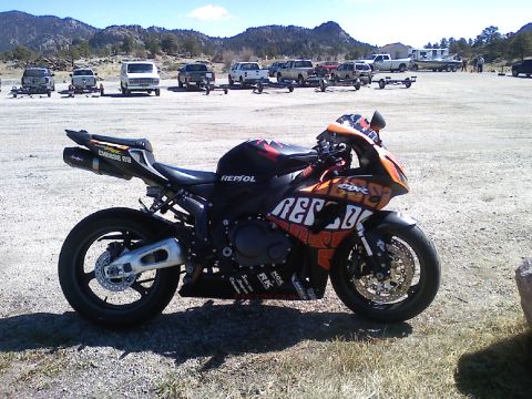 2006 Honda CBR-RR - A 2006 Honda CBR sportbike is parked in a lot with mountains and other vehicles in the background.