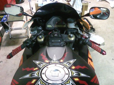 2006 Honda CBR-RR - Close-up view of a motorcycle's cockpit and fuel tank, showing the instrument cluster and handlebars.