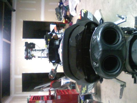 2006 Honda CBR-RR - Close-up view of a motorcycle's rear exhaust system, showing its dual outlets and carbon fiber detailing.