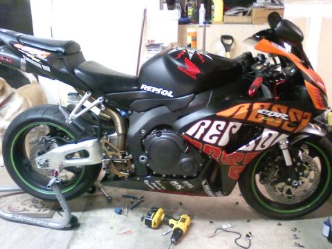 2006 Honda CBR-RR - A 2006 Honda CBR-RR motorcycle, identified by its distinctive body style and livery, is shown in a garage setting.