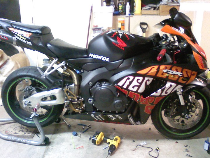 Side view of a black and orange 2006 Honda CBR-RR motorcycle with Repsol livery