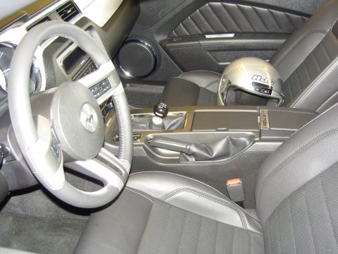 2007 Ford Mustang - The interior of a car features a steering wheel, gear shift, and a helmet resting on the passenger seat.