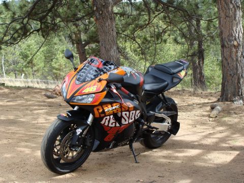 2006 Honda CBR-RR - A 2006 Honda CBR-RR sport motorcycle, '46' and 'REPSOL' graphics, is parked outdoors on a dirt path.