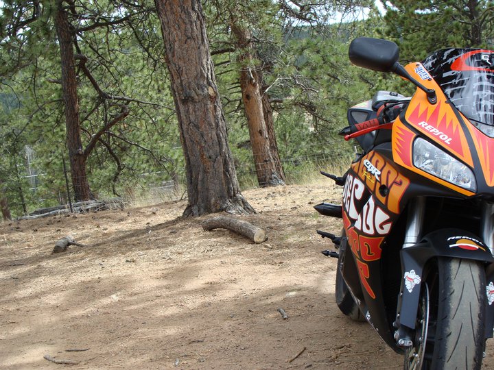Orange and black 2006 Honda CBR-RR motorcycle parked on dirt road