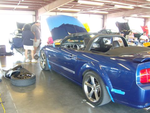 2007 Ford Mustang - A blue 2007 Ford Mustang convertible is displayed indoors with its hood up, alongside other vehicles.
