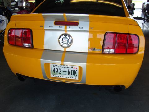 2007 Ford Mustang - Rear view of a yellow 2007 Ford Mustang Shelby with silver racing stripes and a Tennessee license plate.