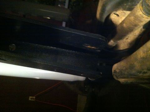 1990 Ford Bronco - A close-up shot reveals the undercarriage of a vehicle, showing structural and mechanical parts.
