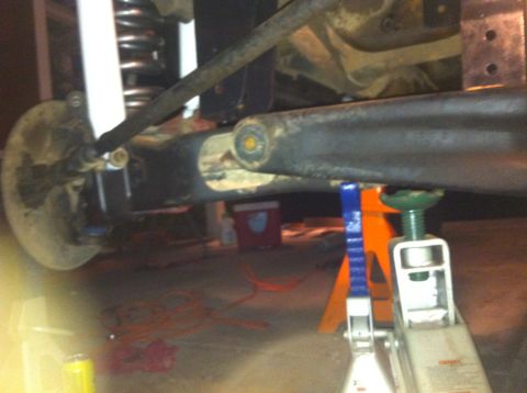 1990 Ford Bronco - Undercarriage components are visible, supported by jack stands.