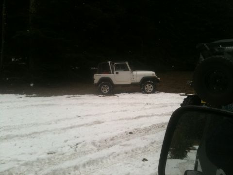 2005 Jeep Wrangler - A white Jeep Wrangler sits parked in a snowy area, with another vehicle visible in the foreground.