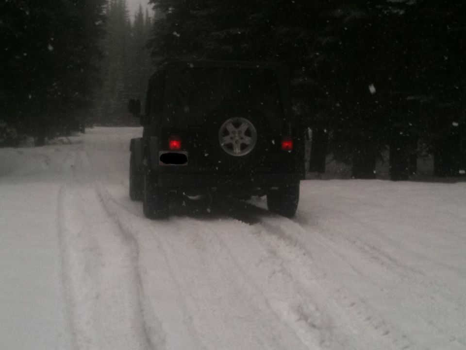 Black Jeep Wrangler rear view in snow