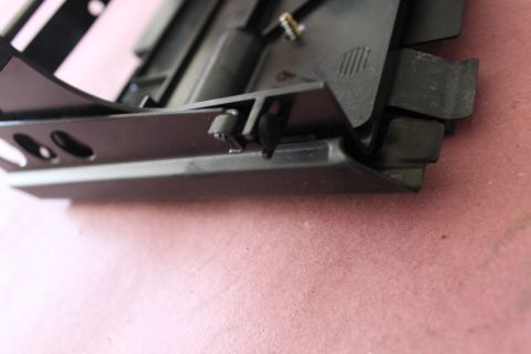 2003 Ford Crown Victoria - A black plastic car part with mounting clips is shown in detail against a pink textured surface.