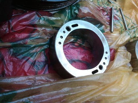 1998 Ford Crown Victoria - Close-up of a metal automotive part with a circular design and several holes.
