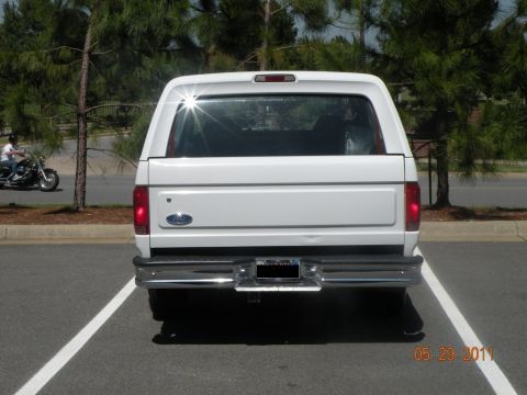 1996 Ford Bronco - Rear view of a white Ford Bronco, showing its tailgate and taillights.