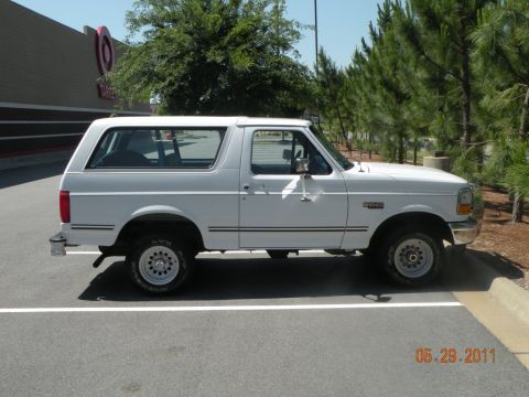 1996 Ford Bronco - Side view of a white 1996 Ford Bronco parked in a lot with a Target store in the background.