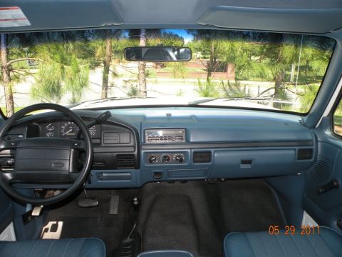 1996 Ford Bronco - The interior of a 1992 Ford F-Series truck is visible, with a blue dashboard and seats.