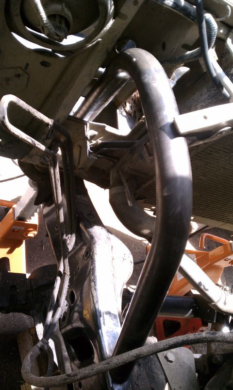 1990 Ford Bronco - Undercarriage view of a vehicle's frame and radiator, with some plumbing visible.