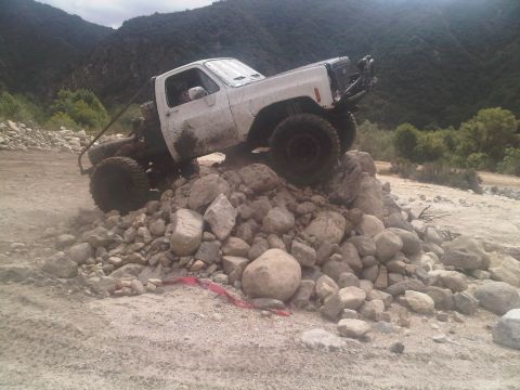 1986 Ford Bronco - Modified pickup truck navigating a rocky terrain.