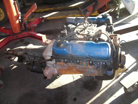 1976 Ford Torino - Engine and transmission assembly, likely from a 1976 Ford Torino, with "POWERED BY FORD" visible on the valve cover.