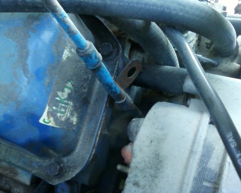 1976 Ford Torino - Close-up view of an engine bay, focusing on a blue valve cover and surrounding components.