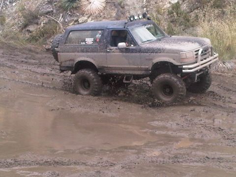 1986 Ford Bronco - This Ford Bronco is navigating a challenging muddy off-road course.