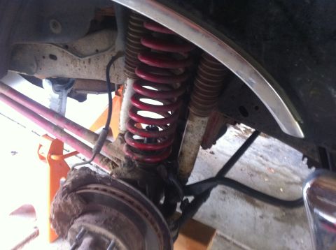 1990 Ford Bronco - Vehicle suspension components, including a red coil spring and shock, are visible in this close-up.