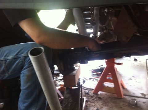 1990 Ford Bronco - Vehicle maintenance in progress with a mechanic working underneath.