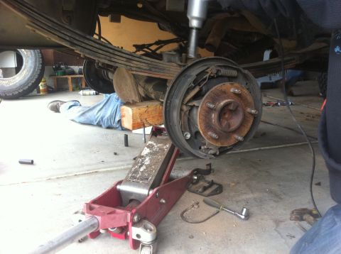 1990 Ford Bronco - Repairing the rear suspension and brakes of a vehicle in a garage setting.