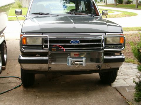 1991 Ford Bronco - This Ford Bronco features a custom winch bumper and grille guard, with a "4x4" badge visible on the fender.