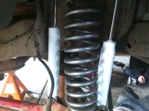 1990 Ford Bronco - The image shows the vehicle's suspension system, including coil springs and shock absorbers, with a SuperMotors watermark.