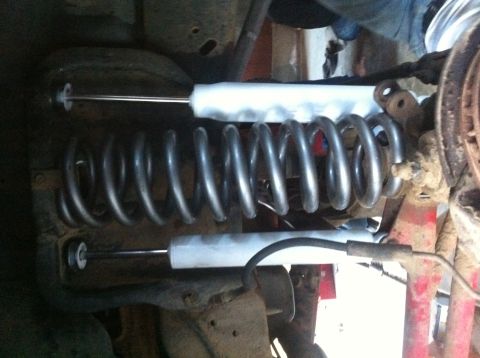 1990 Ford Bronco - Close-up view of a vehicle's suspension system, showing a large coil spring and shock absorber.