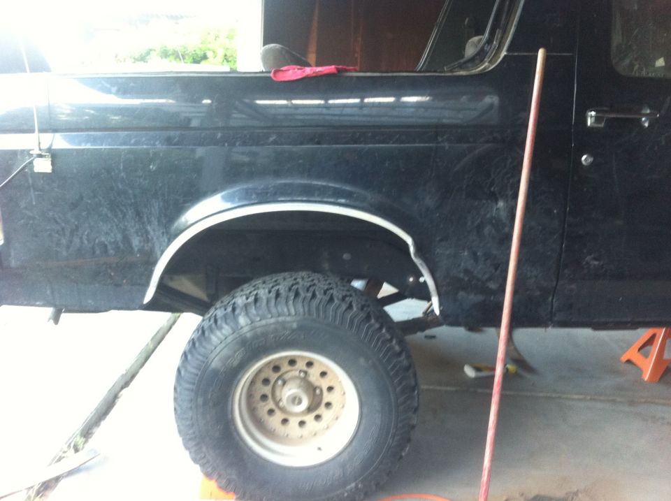 Black 1990 Ford Bronco side view, lifted with large tires