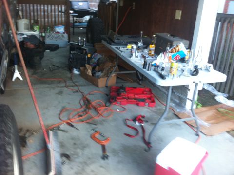 1990 Ford Bronco - Garage scene with tools and a person working on a vehicle.