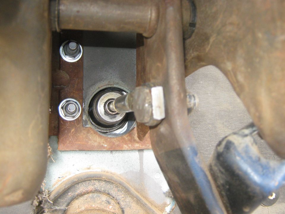 Close-up of a vehicle's clutch linkage mechanism with bolts and metal components