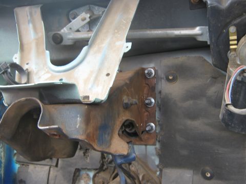 1978 Ford Bronco - Close-up view of corroded metal parts and mechanical linkages within a vehicle's structure.