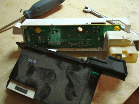 2002 Toyota 4Runner - Disassembled car stereo components, including a circuit board and plastic housing, are laid out on a workbench.