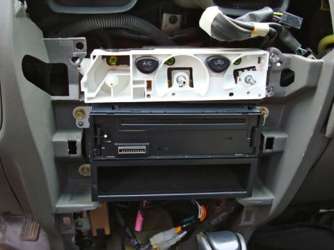 2002 Toyota 4Runner - The dashboard of a car shows climate controls and an aftermarket stereo unit with visible wiring.