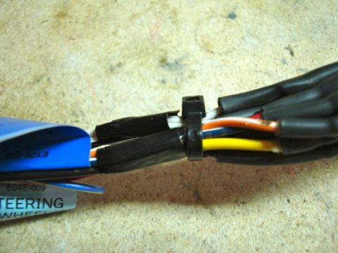 2002 Toyota 4Runner - A close-up shot shows a wiring harness secured with zip ties, with a blue label indicating it's for a steering wheel.
