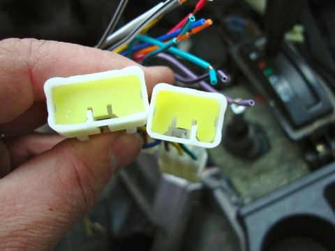 2002 Toyota 4Runner - Two yellow wiring harness connectors are held in hand, with a tangle of colorful wires visible.